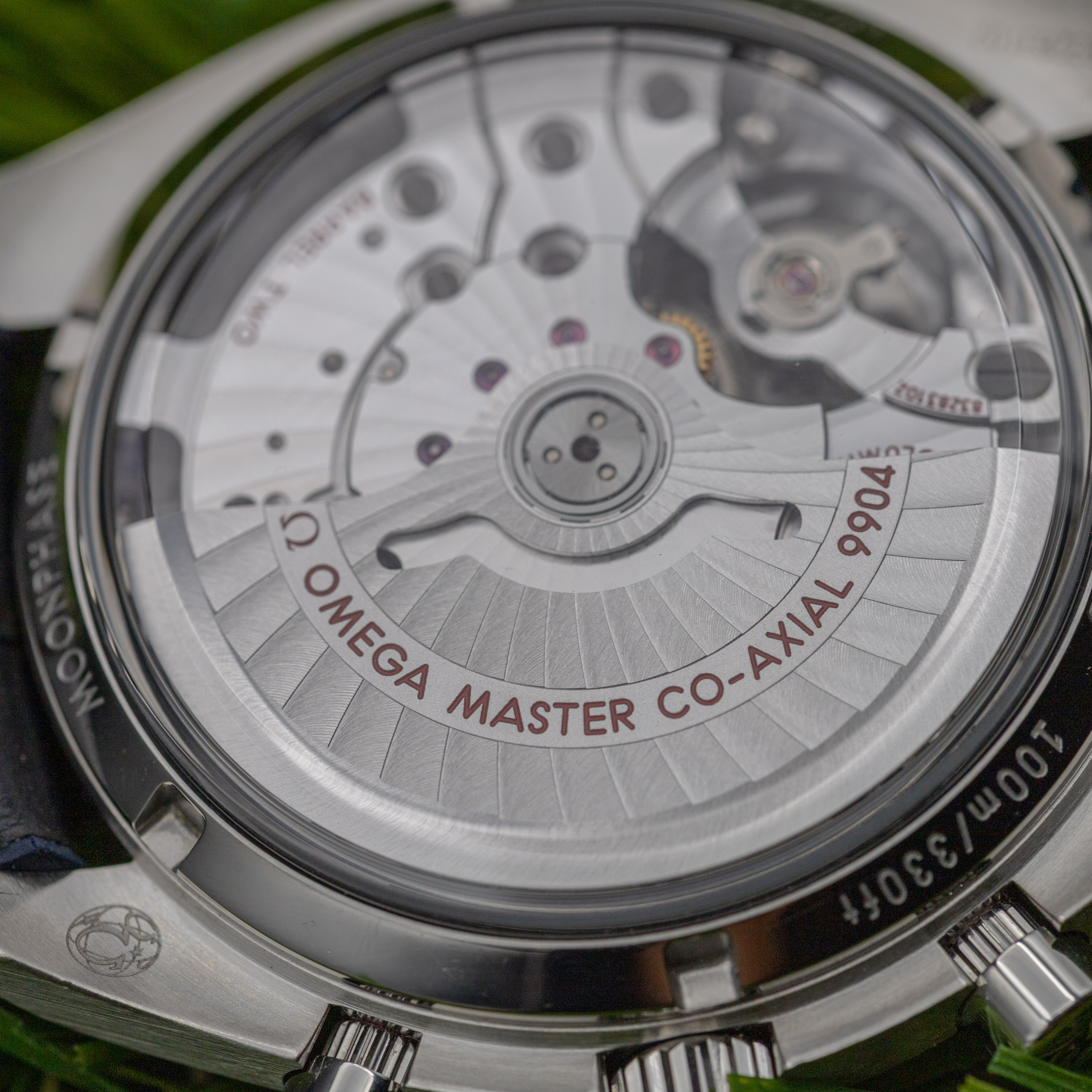 Omega Speedmaster Moonphase Caliber 9904 movement through exhibition case back close-up